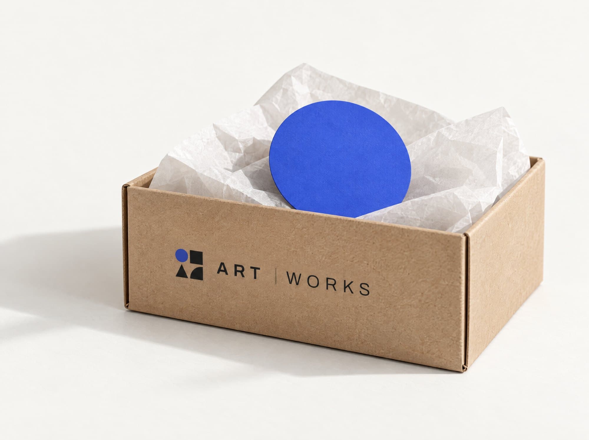 Kraft shipping box with the ArtWorks logo and a cobalt disc inside